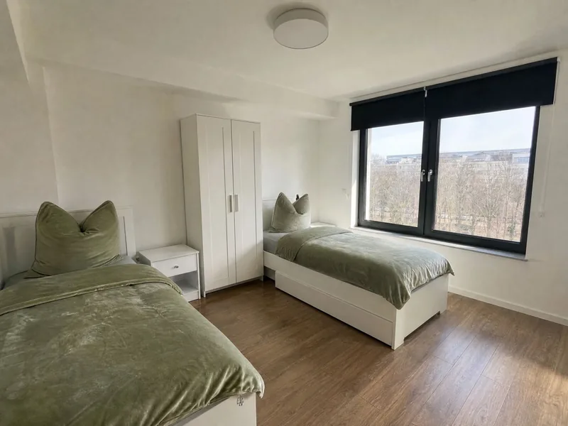 Geräumiges Zweibettzimmer mit Kleiderschrank und zwei Fenstern